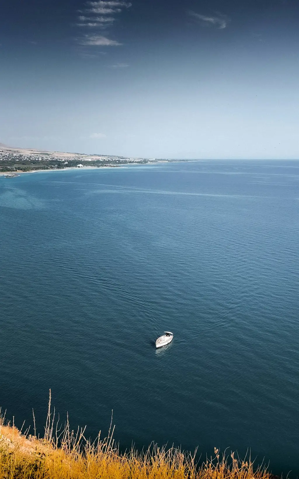 A white boat floating on the lake.